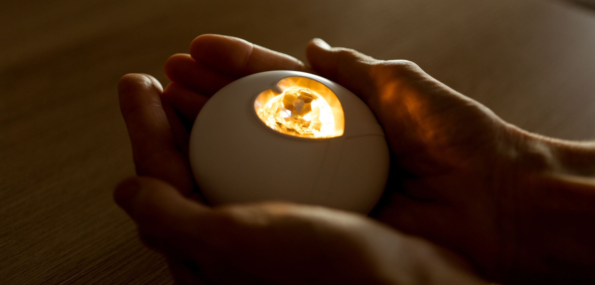 Eine Hand hält das HerzLicht, das Kraft und Mut im Prozess des Trauerns schenkt.